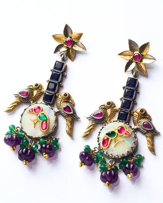 Side view of The House of Birds Earrings highlighting layered depth, raised bird motifs, stone setting, and hanging drop movement