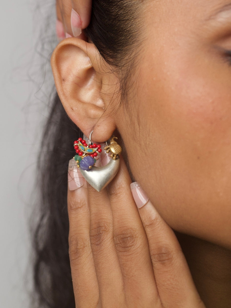 Heart-shaped handcrafted silver hoop earrings with enamel bird, violet beads, and red seed bead detailing