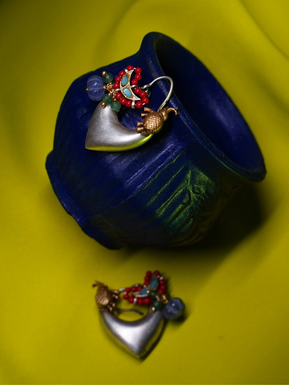 Heart-shaped handcrafted silver hoop earrings with enamel bird, violet beads, and red seed bead detailing