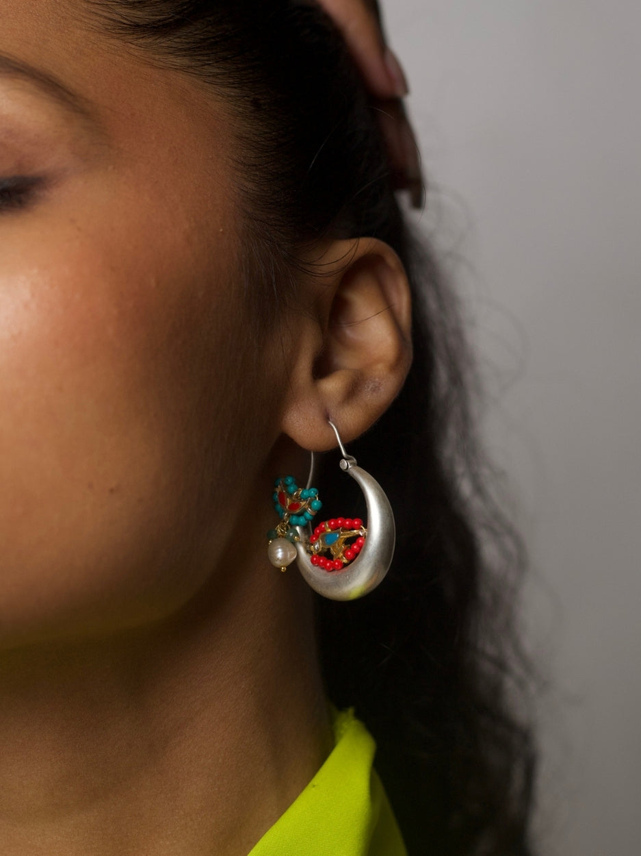 Pair of circular 92.5 silver hoop earrings with gold parrot motif, red and turquoise beads, pearl accent, and enamel detail