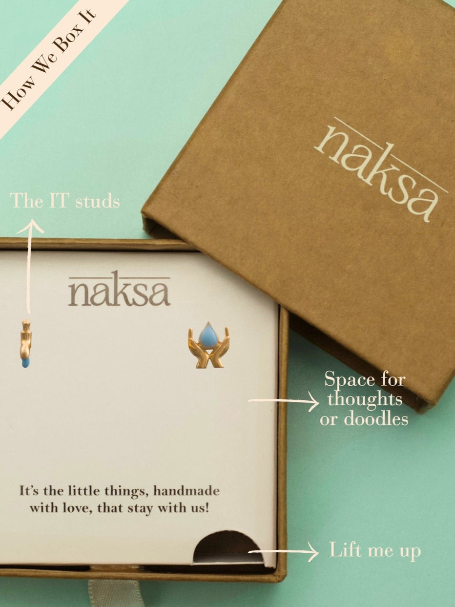 Save Water Studs by Naksaâmismatched earrings in 925 silver with a hand-holding-drop and dripping tap design in gold polish and blue enamel.