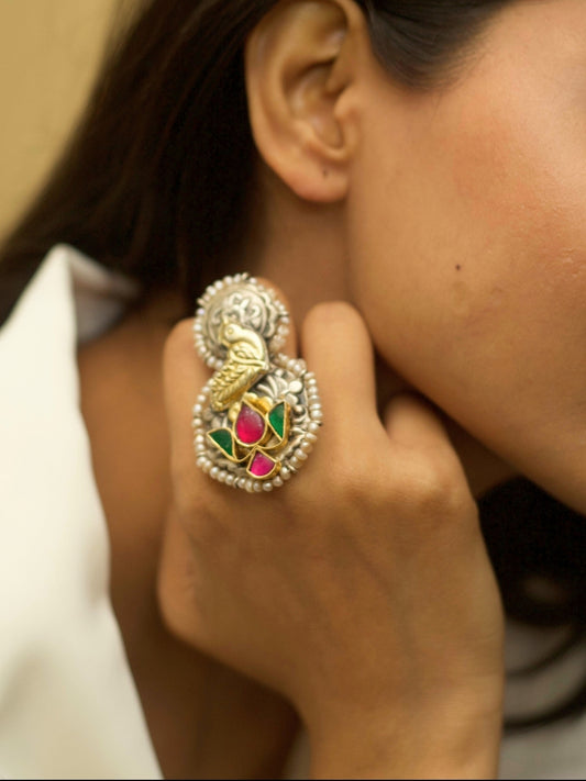Oxidized 925 silver statement ring with golden dove and lotus motifs, handcrafted by Naksa.