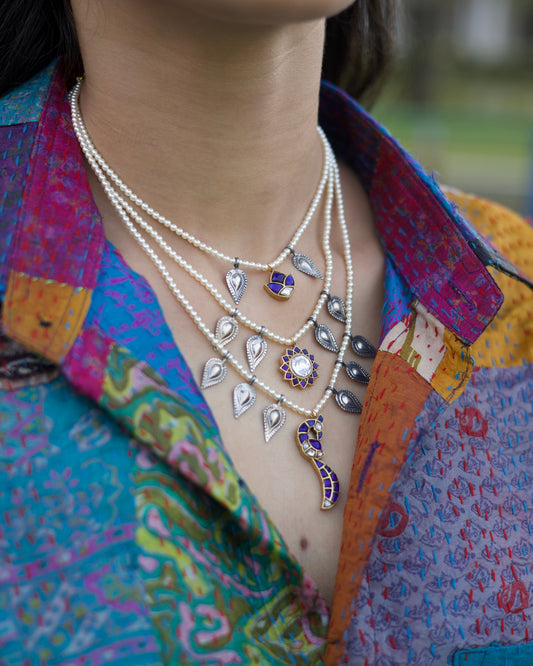 Layered 925 silver gold-polished pearl necklace with silver paisley charms, blue stone lotus pendant and crescent drop centerpiece