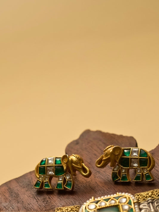 Pure 925 silver elephant-shaped stud earrings with gold polish, moissanite-like stones, and green accents by Naksa.