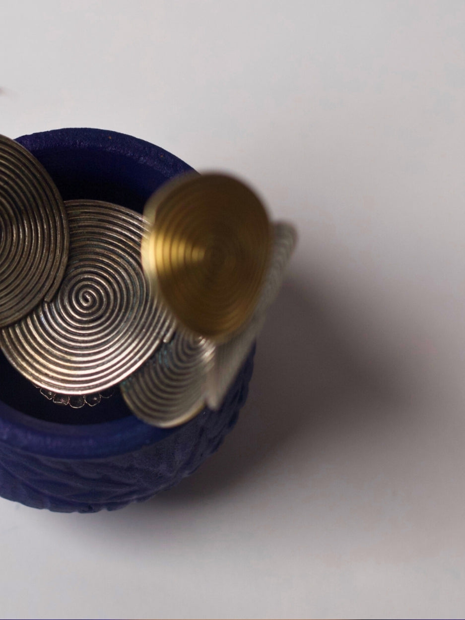 Handcrafted silver cuff with spiral base, navratna enamel, and sculptural motifs in 92.5 silver by Naksa