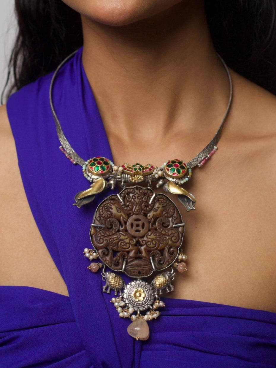 Handcrafted 92.5 silver hasli necklace featuring dark carved animal motif, enamel detailing, pearls, elephants, and fusion gold-polished accents, styled on model