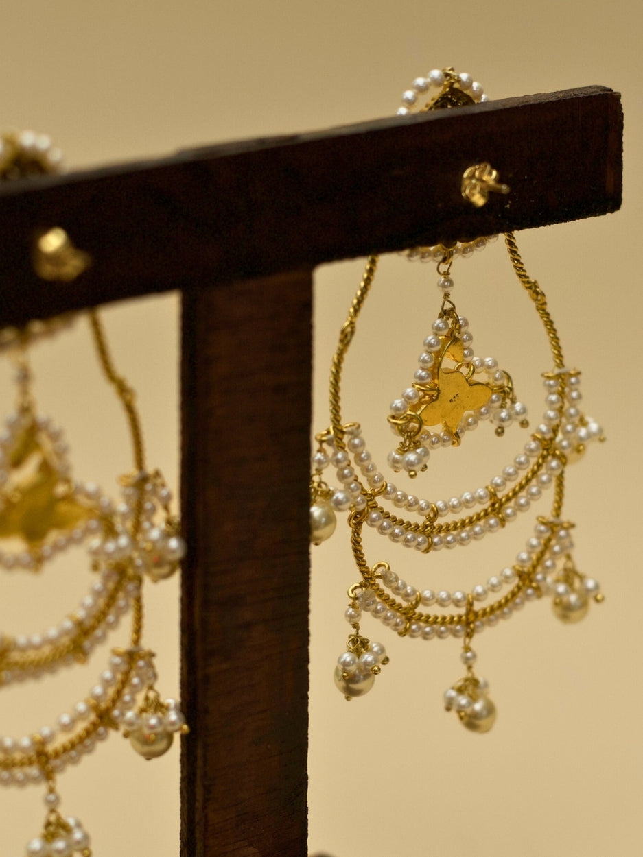 Tyohaar Jhumkas by Naksa—925 silver earrings with gold polish, layered pearl chains, kundan floral drops, and festive bell charms.