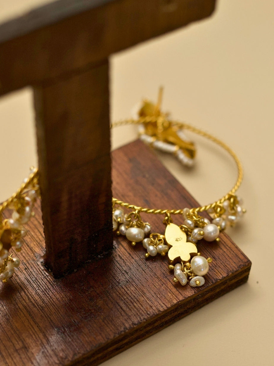 Jhoom Jhumkas by Naksa—gold polished 925 silver hoop earrings with red kundan drops, pearl fringe, and twisted wire design.