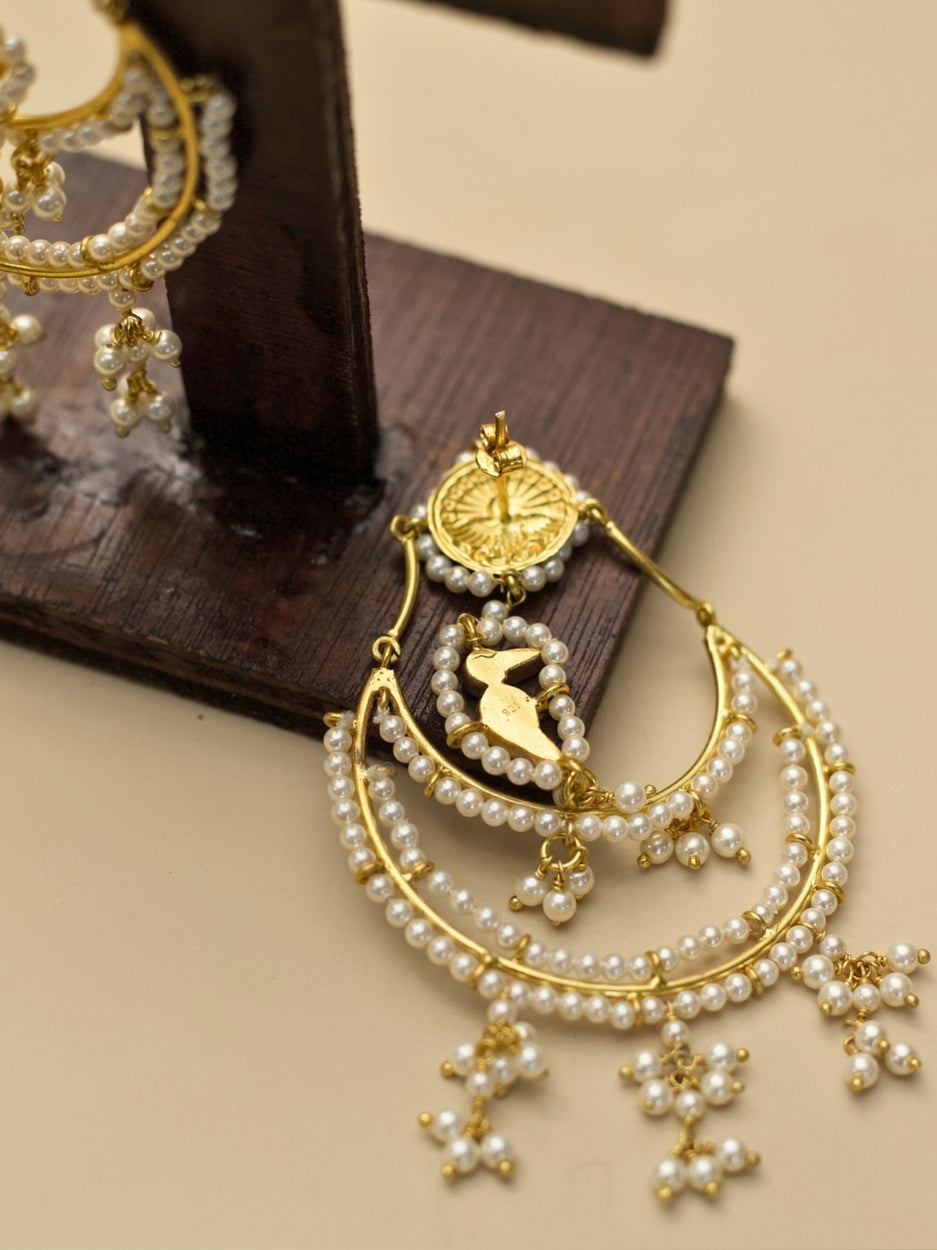 Nazaara Jhumkas by Naksa—gold polished 925 silver earrings with layered pearl crescents, kundan detailing, and a central parrot motif.