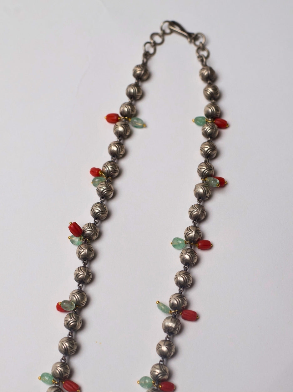 Antique silver Lakshmi pendant necklace with turquoise enamel tusk motifs, moonga and pearl accents, handcrafted in tribal style.