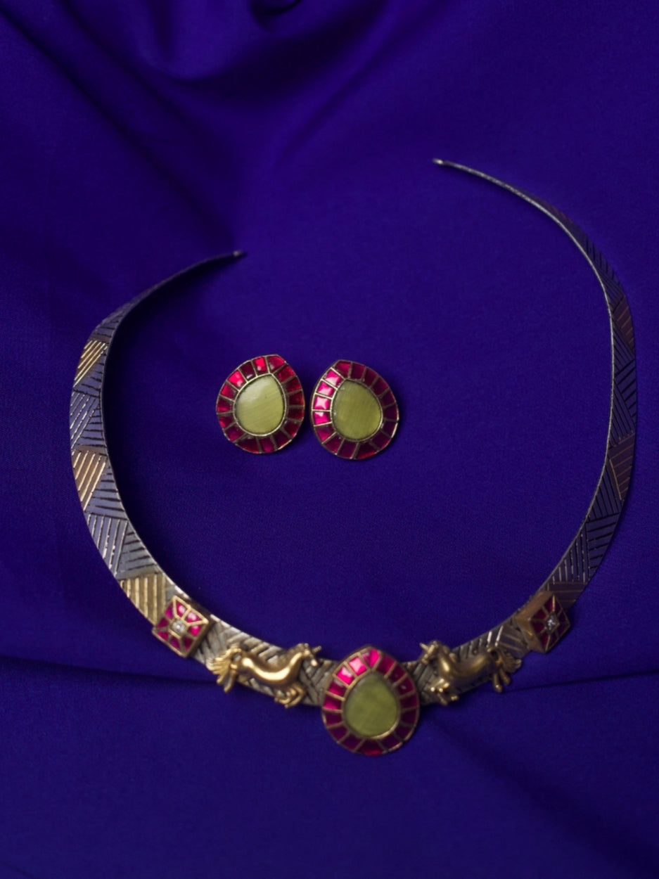 Close-up of The Enchanted Collar Torque Set in pure 92.5 silver featuring red enamel, lemon stone center, and miniature gold dog motifs — styled on model.