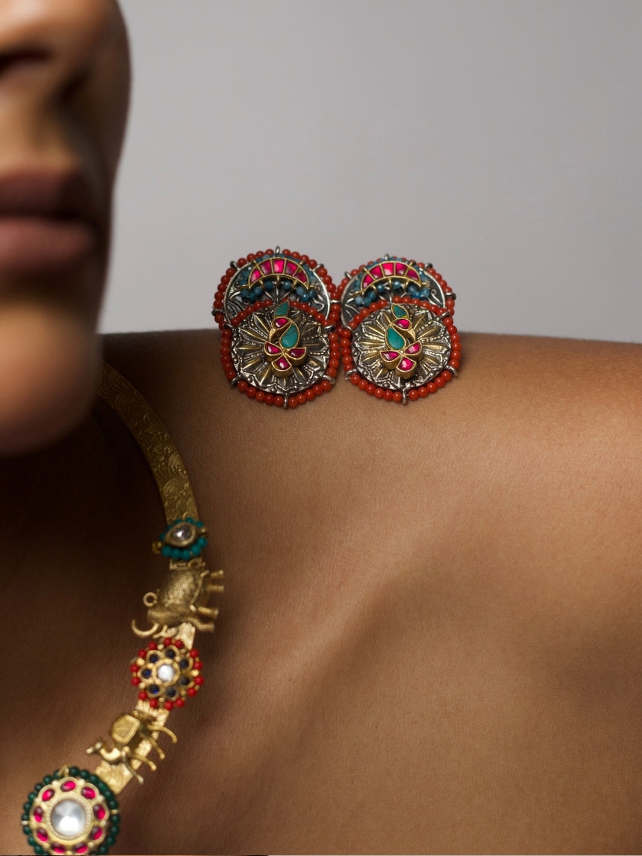 Close-up of The Tusker March Set – handcrafted 92.5 silver torque necklace with gold-plated elephant motifs and enamel detailing in red and green, styled with matching earrings.
