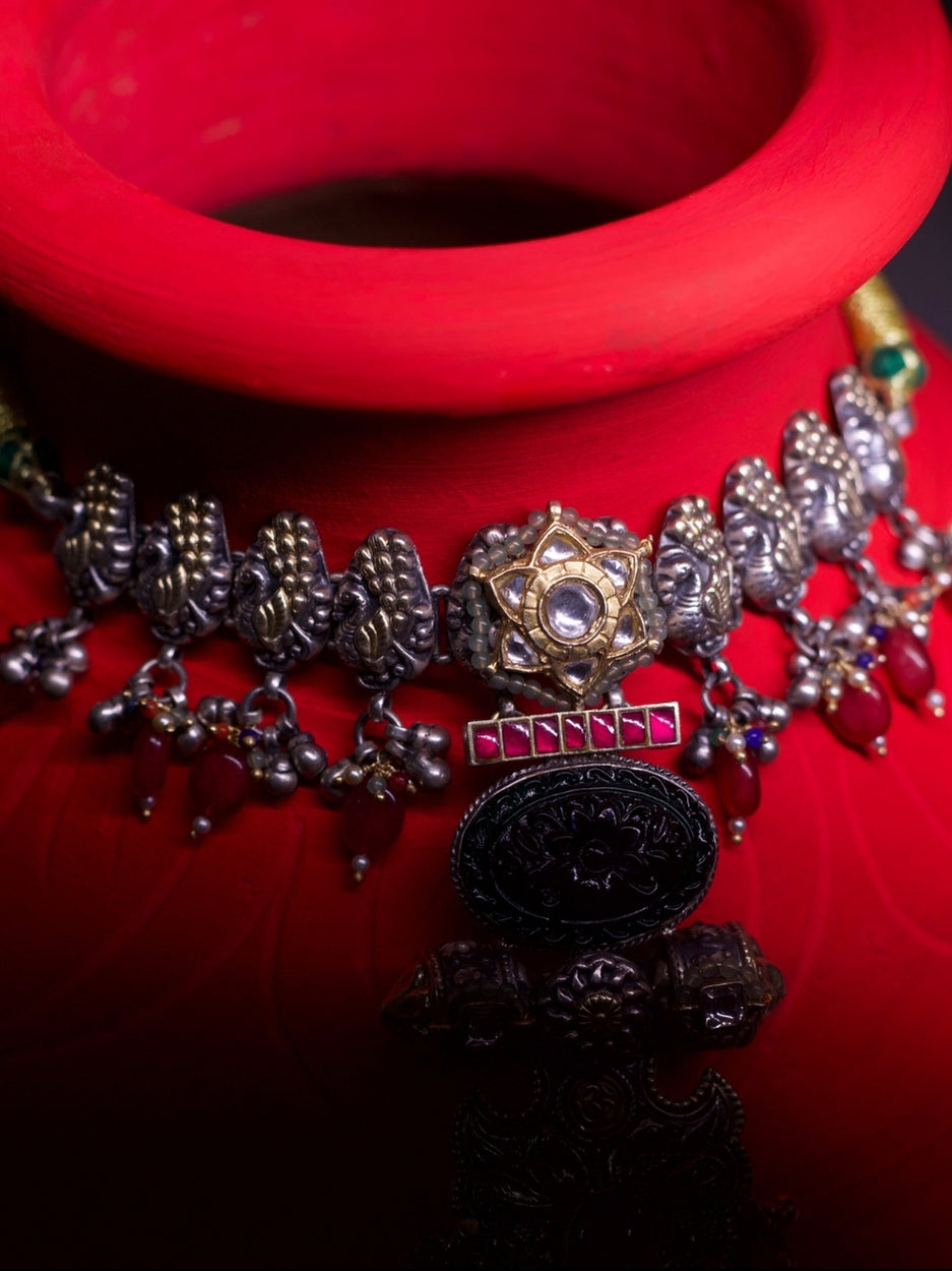 Close-up of The Garland Choker in 92.5 silver with red beads, temple-inspired details, and intricate golden accents