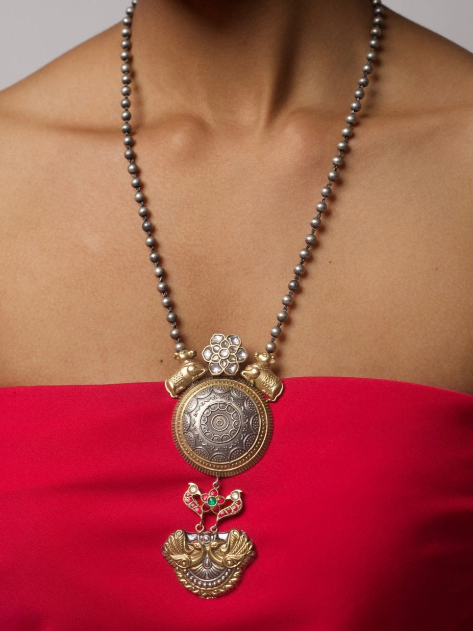 Close-up of handcrafted 92.5 silver necklace with cow and peacock motifs, floral accents, and antique-finished beads