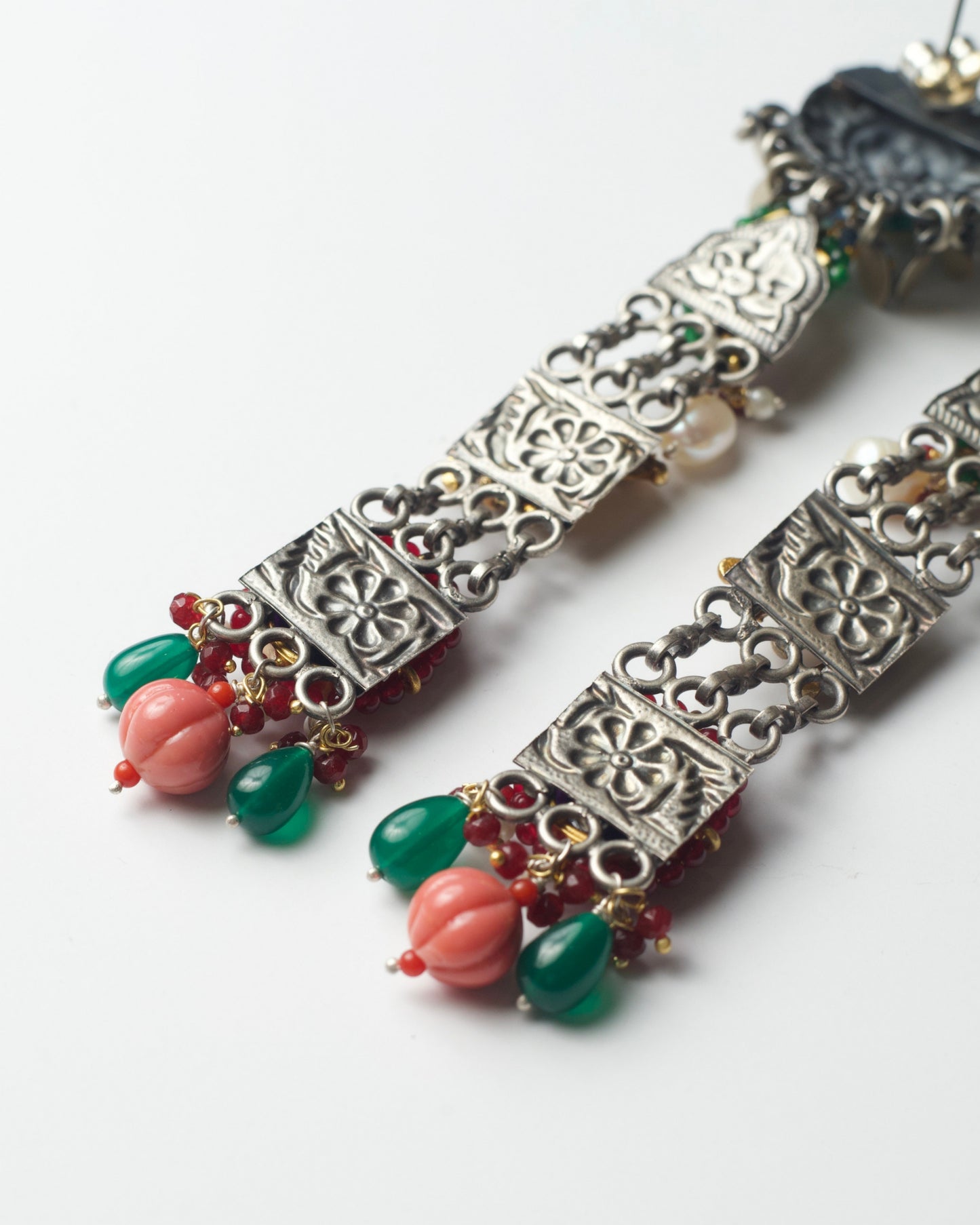 Back of handcrafted long tassel earrings with layered chains and bold colours