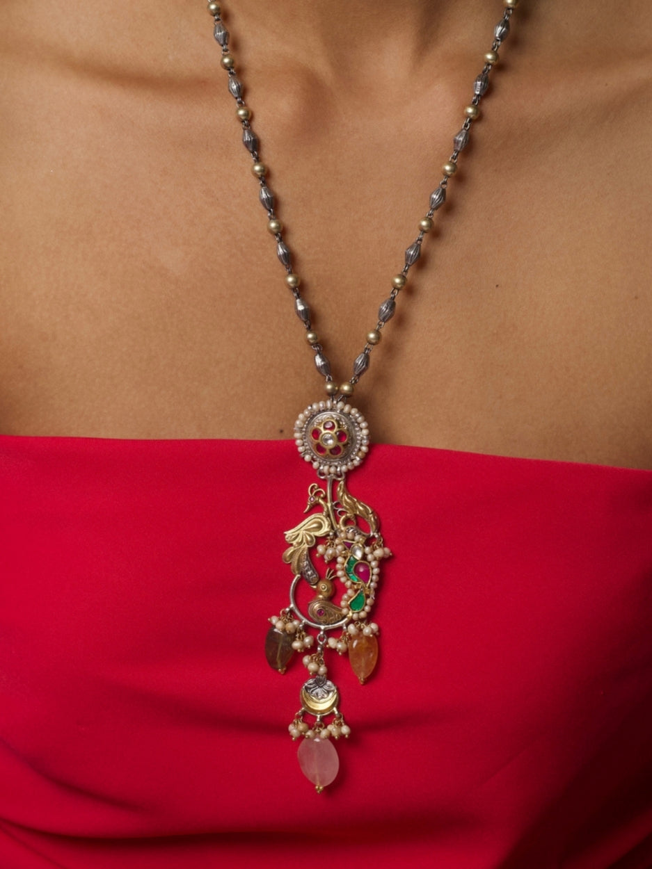 Handcrafted silver necklace with bird motifs, gemstone drops, and temple-style detailing in fusion design