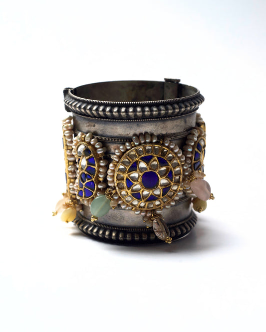 Wide oxidised 925 silver cuff featuring circular kundan medallions in deep blue and ivory, framed with pearls and gold-toned detailing.