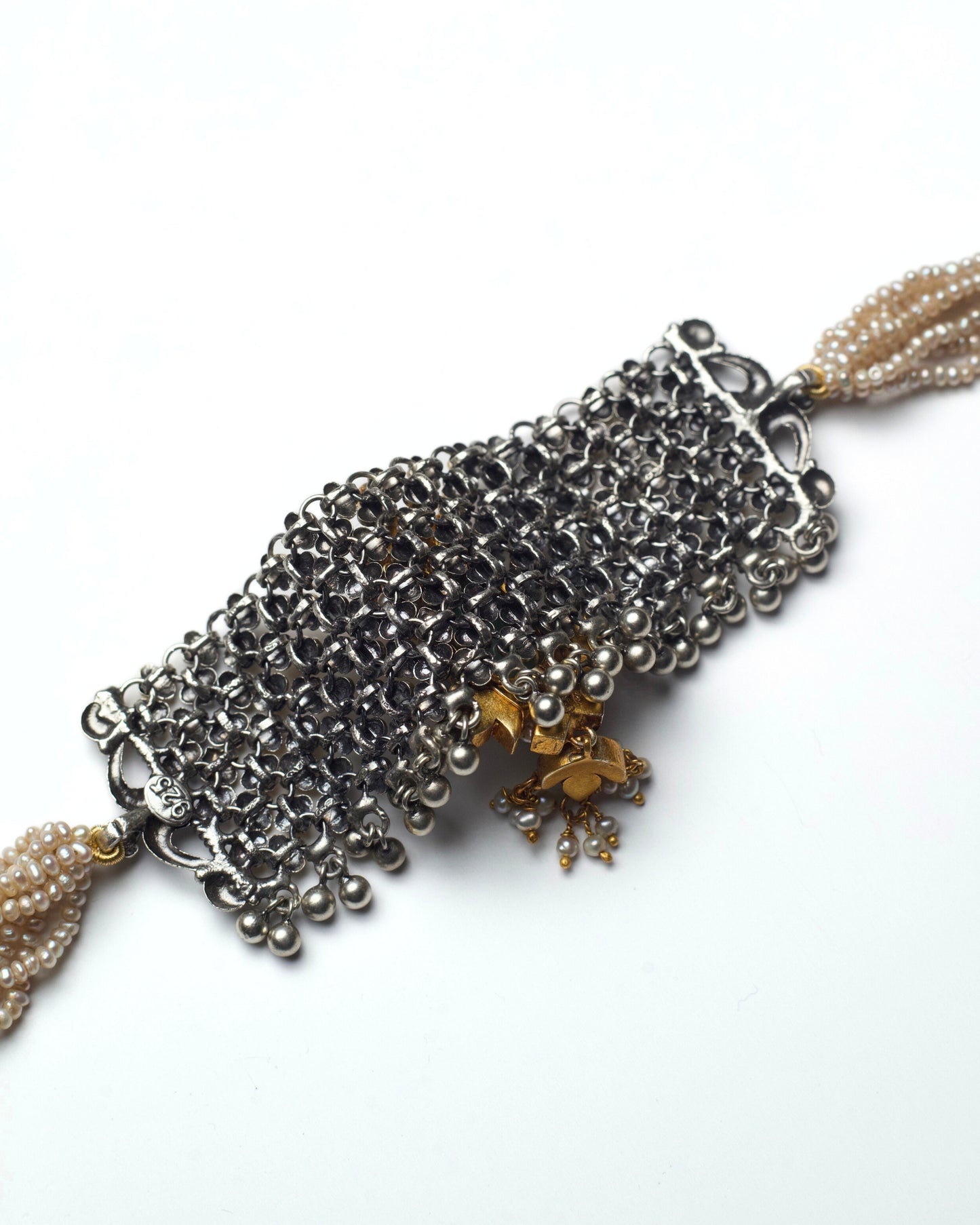 Back of dual-tone silver jaali choker with central green stone and pink kundan droplet detailing