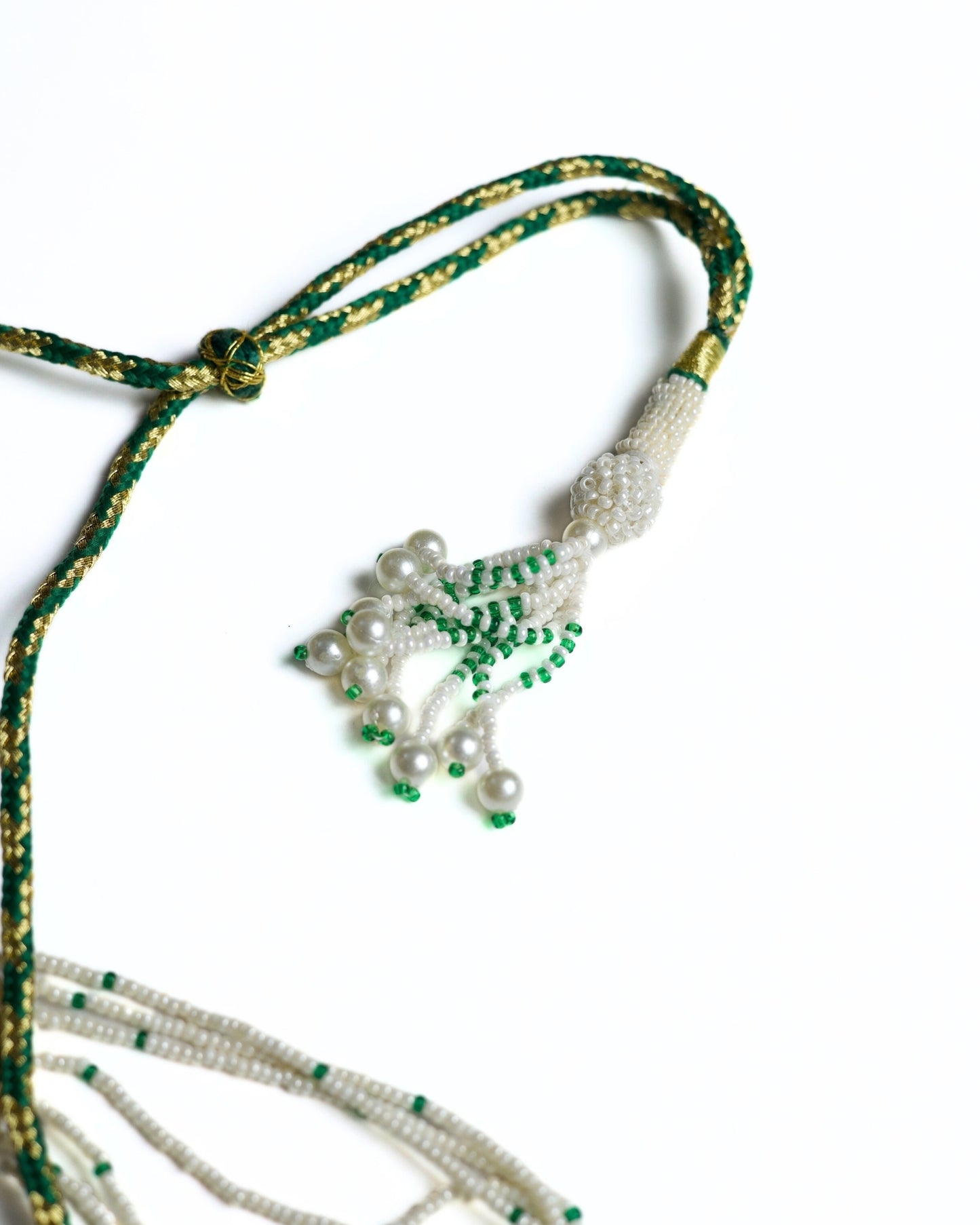 Multi-strand pearl necklace with emerald bead highlights and crescent pendant