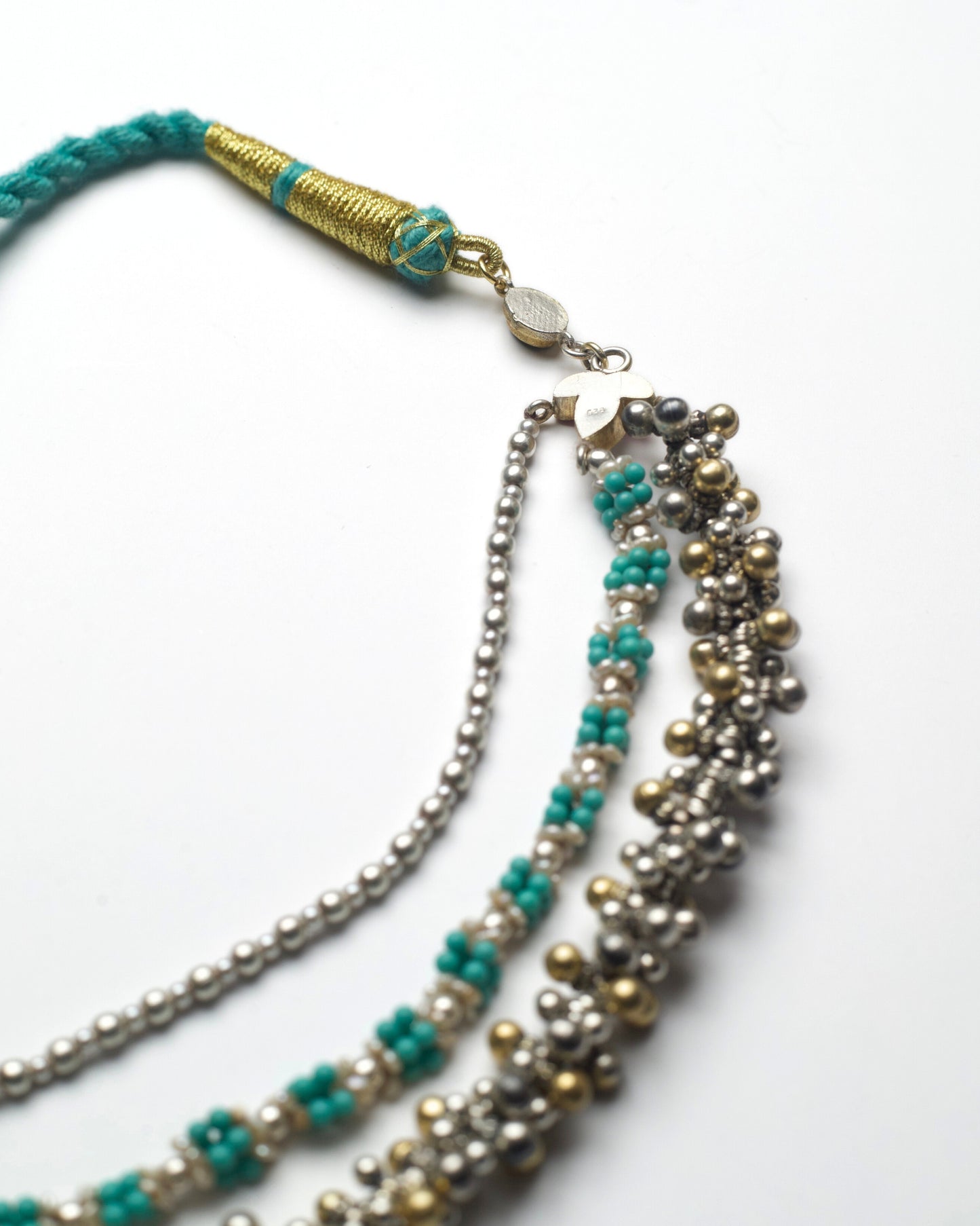 back of oxidised silver ghungroo layers with turquoise bead clusters and pearl detailing in a handcrafted necklace.