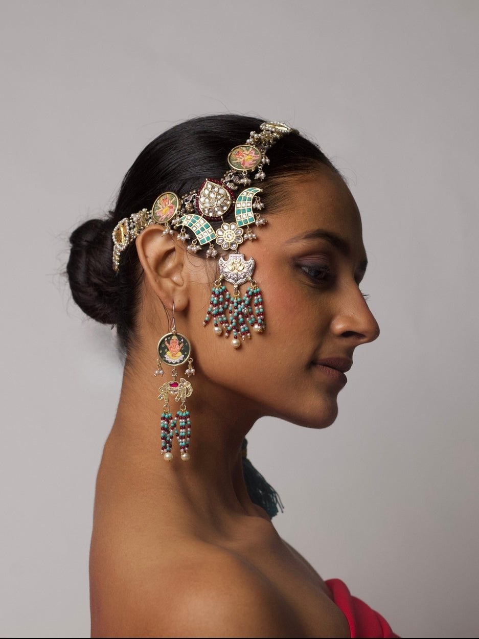 Model wearing The Divine Contradictions Set – a pure silver headpiece and earring set featuring hand-painted deity motifs, kundan detailing, and pearl bead tassels.
