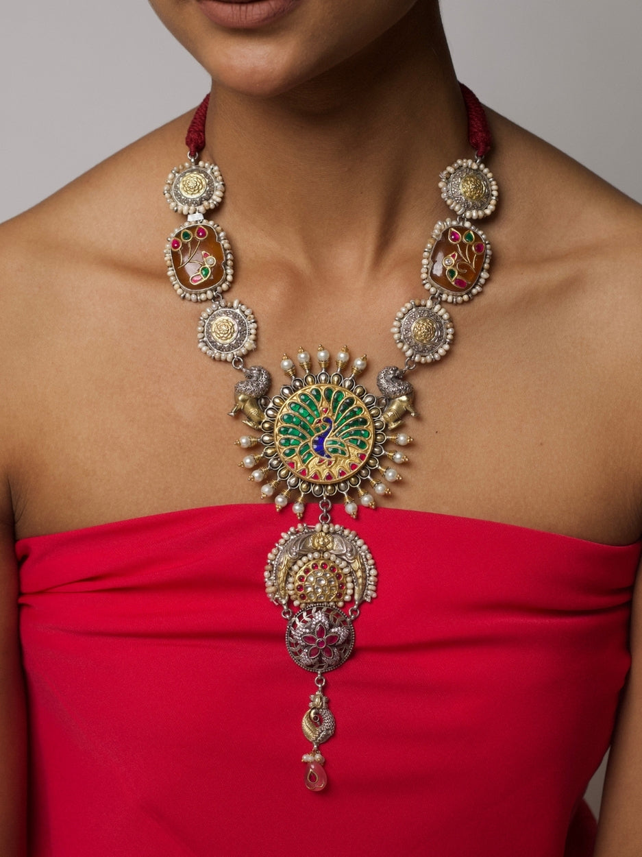 Close-up of Sheesh Mahal Necklace in 925 silver featuring central peacock enamel motif, side gold floral accents, and silver architectural drops.