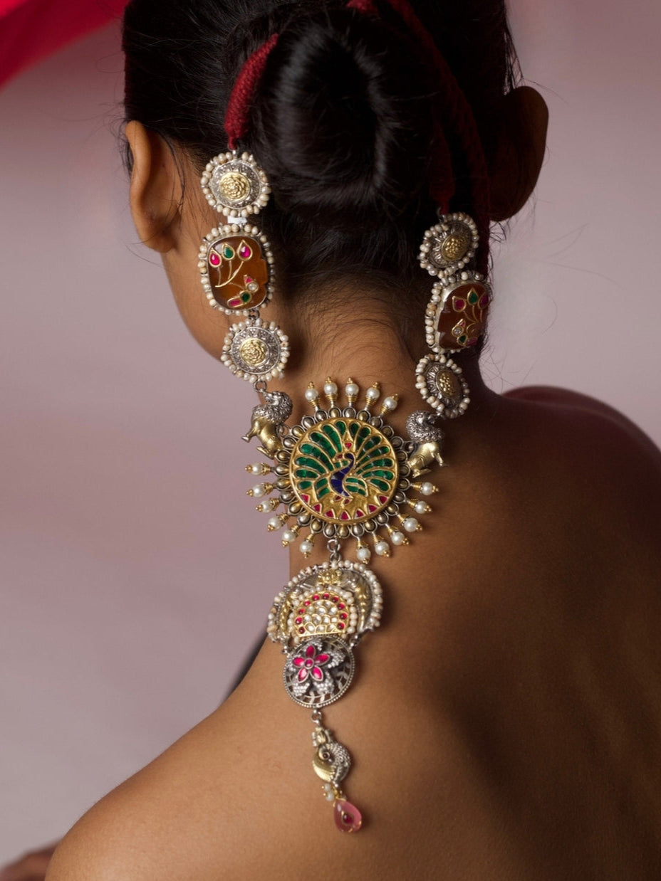 Close-up of Sheesh Mahal Necklace in 925 silver featuring central peacock enamel motif, side gold floral accents, and silver architectural drops.
