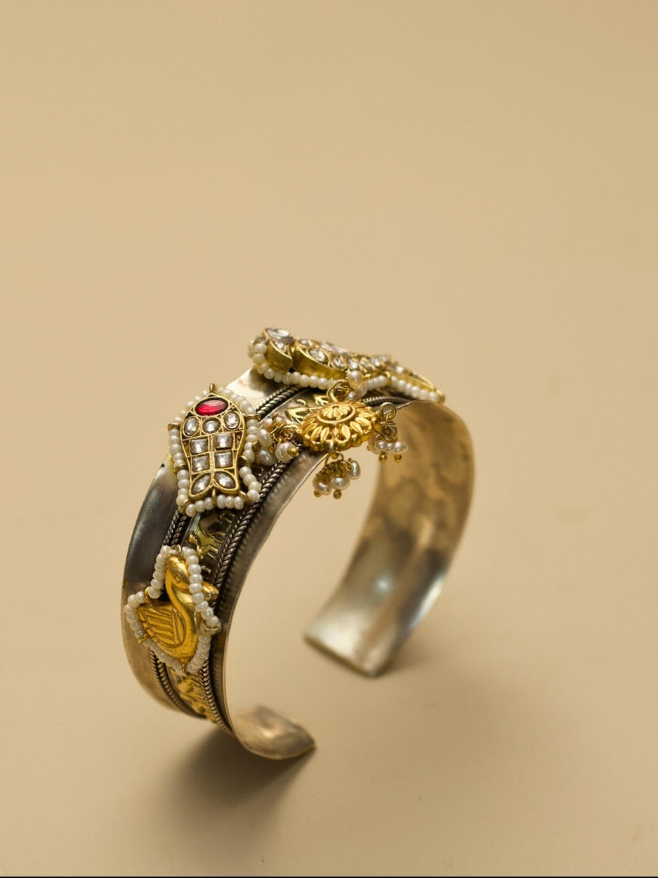 Close-up of gold and red accented bangle with animal motifs