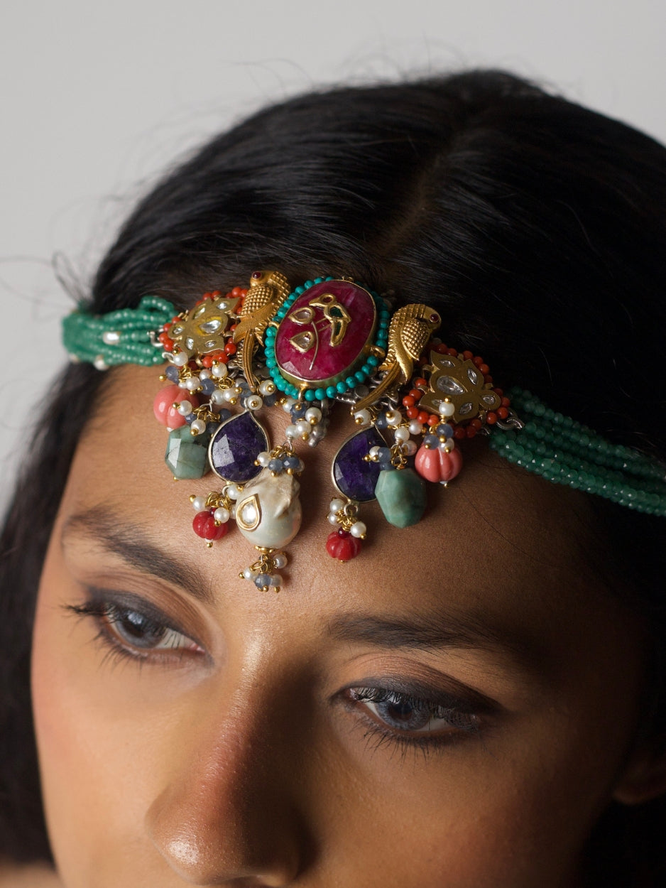 Close-up of Jewel of the Court Choker in 92.5 silver with parrot motifs, carved red center stone, kundan accents, coral and pearl drops