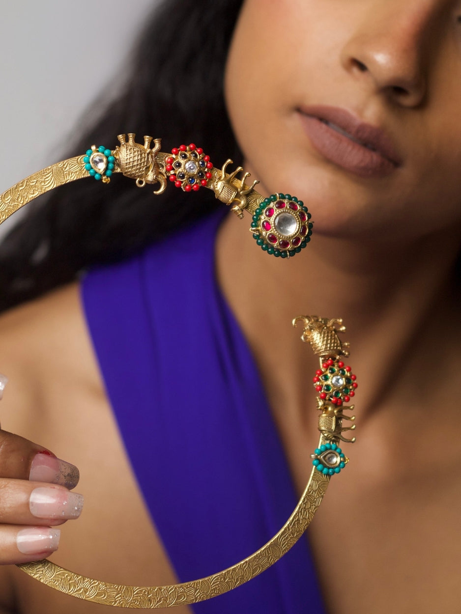 Close-up of The Tusker March Set – handcrafted 92.5 silver torque necklace with gold-plated elephant motifs and enamel detailing in red and green, styled with matching earrings.