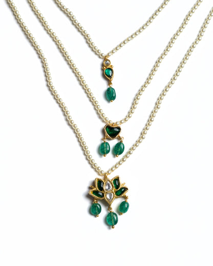Three-layered 925 silver pearl necklace with emerald heart detail and lotus-inspired kundan pendant with green stone drops.