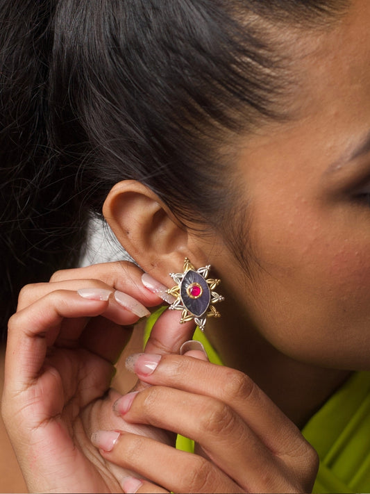 Close-up of dual-tone eye-shaped silver stud with red centre and star-shaped gold detailing from Naksa