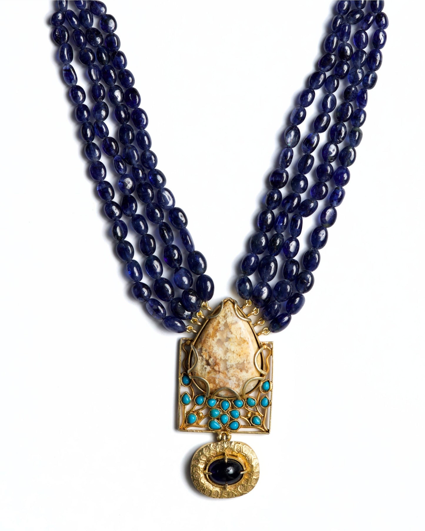 Four-strand indigo bead necklace in 925 silver with large marbled stone pendant, turquoise accents, and hammered gold drop detail.