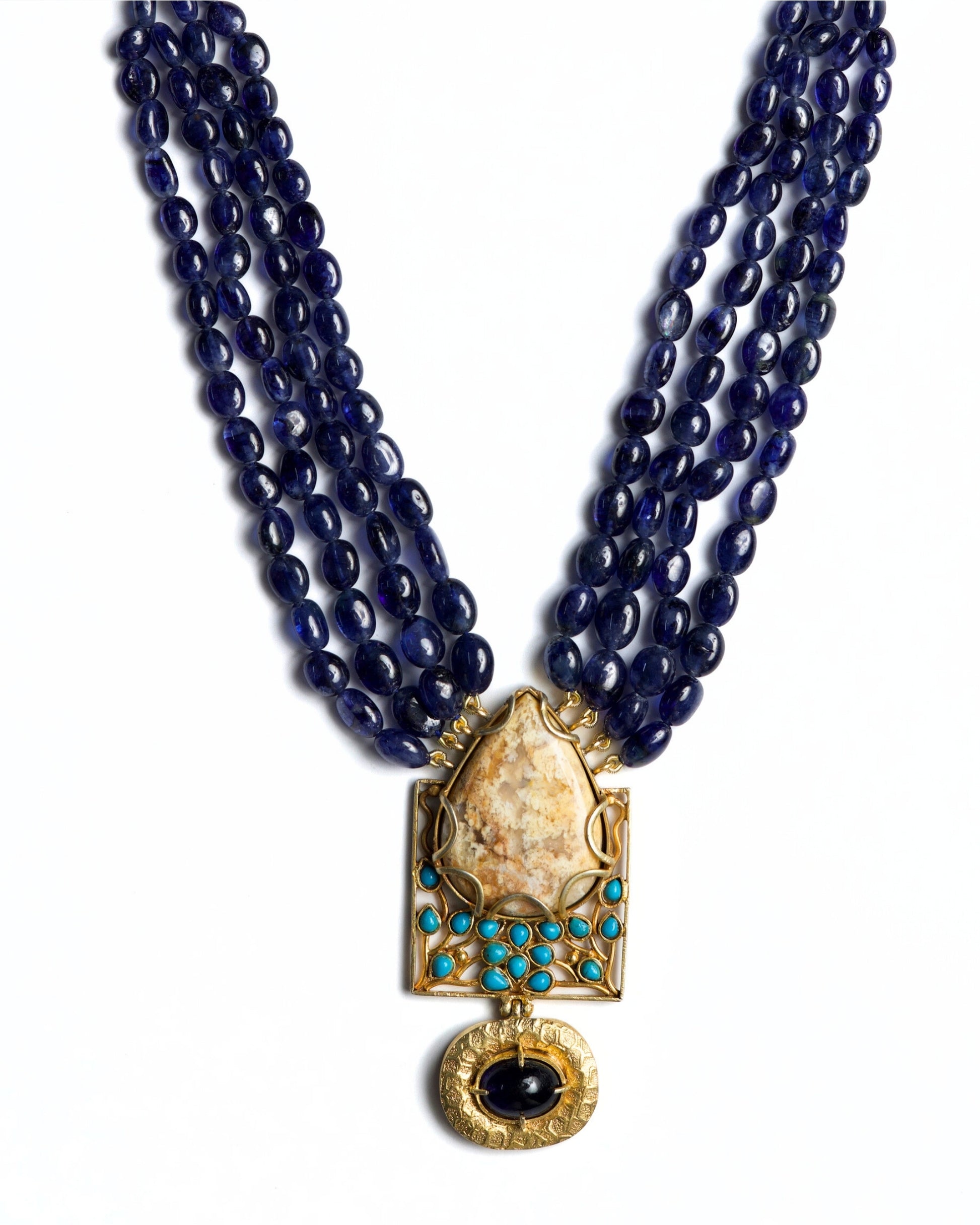 Four-strand indigo bead necklace in 925 silver with large marbled stone pendant, turquoise accents, and hammered gold drop detail.