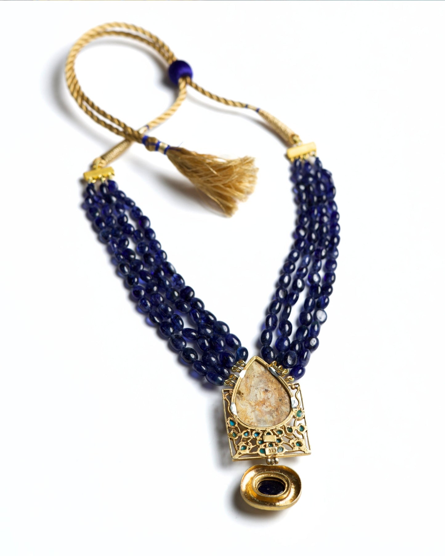 Four-strand indigo bead necklace in 925 silver with large marbled stone pendant, turquoise accents, and hammered gold drop detail.