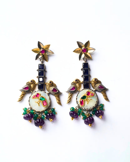 Front view of The House of Birds Earrings showing floral stud, central white stone with bird detailing, side bird motifs, and amethyst-toned drop clusters