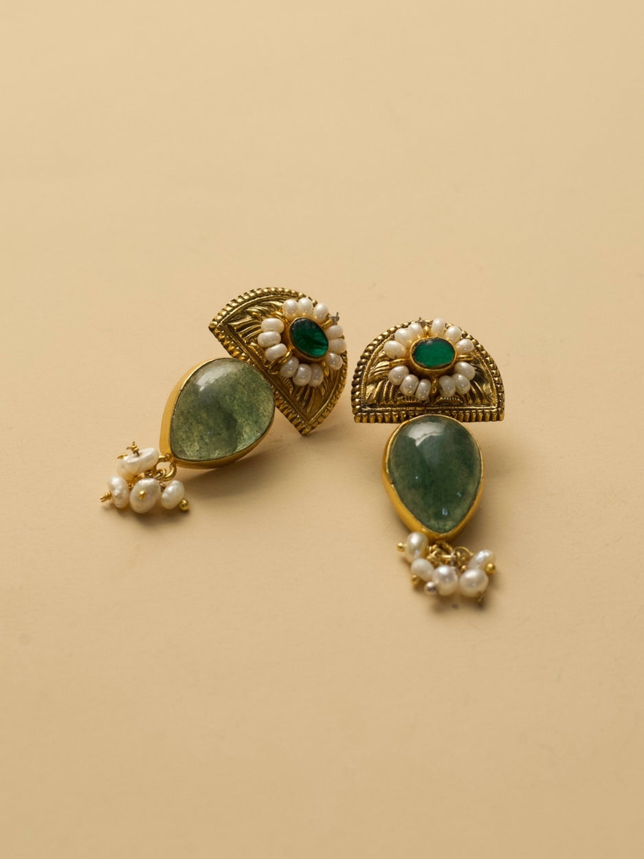 Aurora Drops Earrings by Naksa with golden half-sun motif, translucent green stone, and pearl accents.