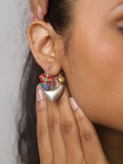 Heart-shaped handcrafted silver hoop earrings with enamel bird, violet beads, and red seed bead detailing
