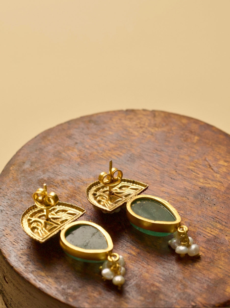 Aurora Drops Earrings by Naksa with golden half-sun motif, translucent green stone, and pearl accents.