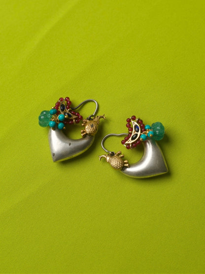 Heart-shaped 92.5 silver hoop earrings with golden elephant, green bead, turquoise and red accents, and crescent motif on lime green backdrop