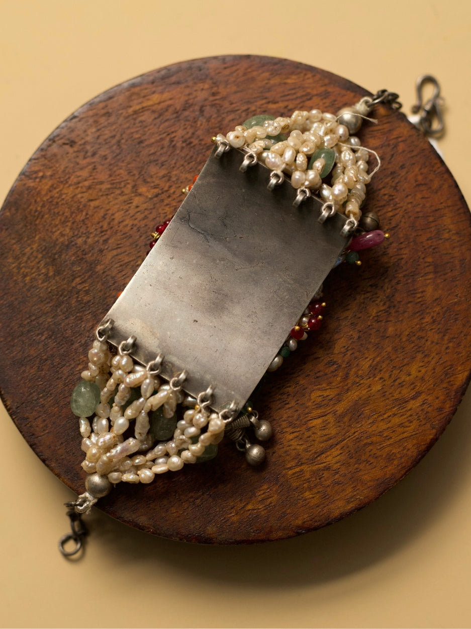 Exquisite pearl and kundan bracelet in pure 925 silver with sea-green, teal, blue, and red stones by Naksa.