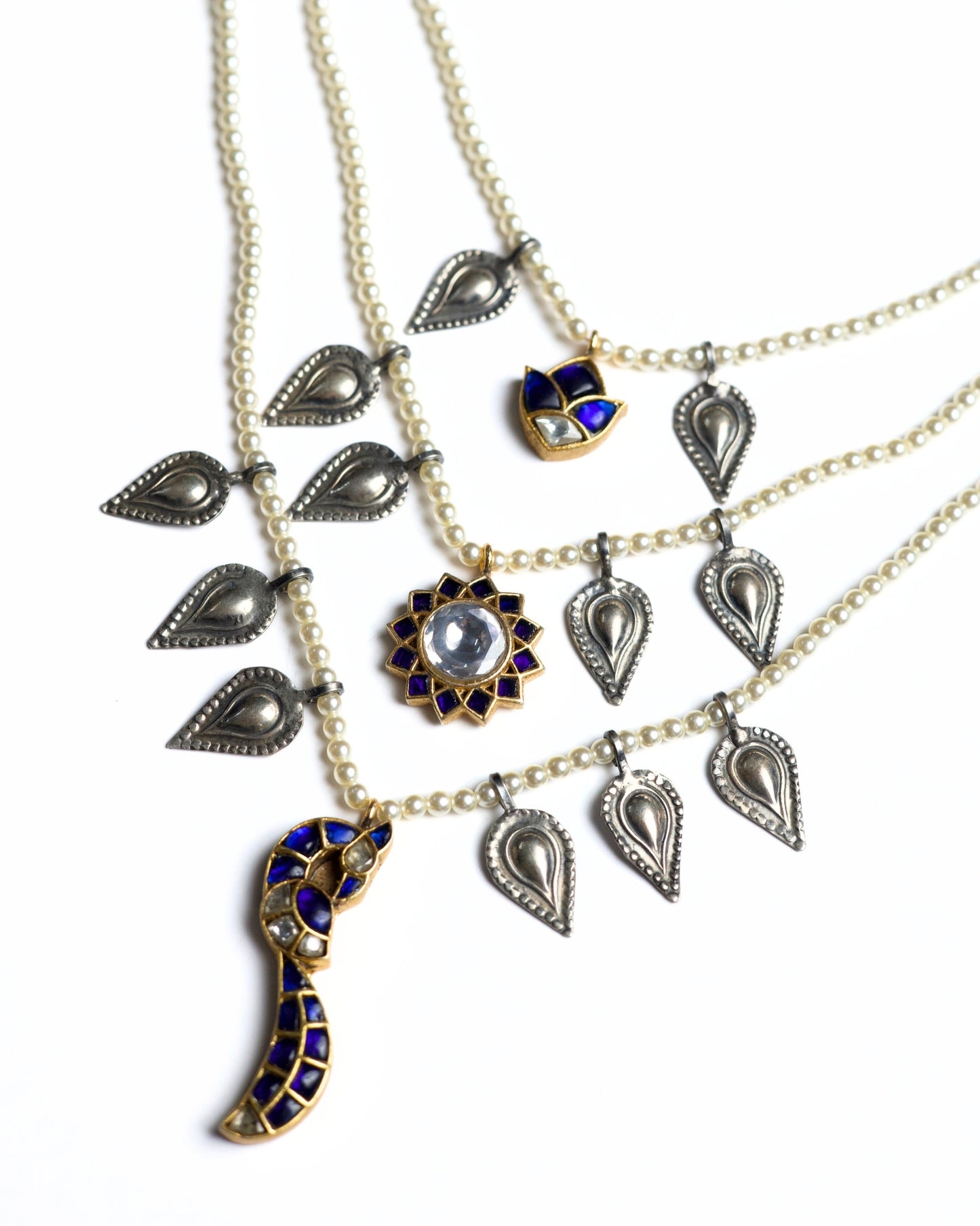 Layered 925 silver gold-polished pearl necklace with silver paisley charms, blue stone lotus pendant and crescent drop centerpiece