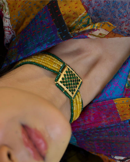 Close-up of a 925 silver gold-polished choker with diagonal yellow and green bead strands and a square lattice centre panel.