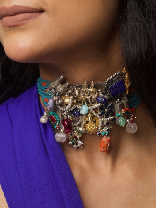 Close-up of a handcrafted 92.5 silver choker with temple and goddess motifs, red and green stonework, gold accents, and layered pearl strands.