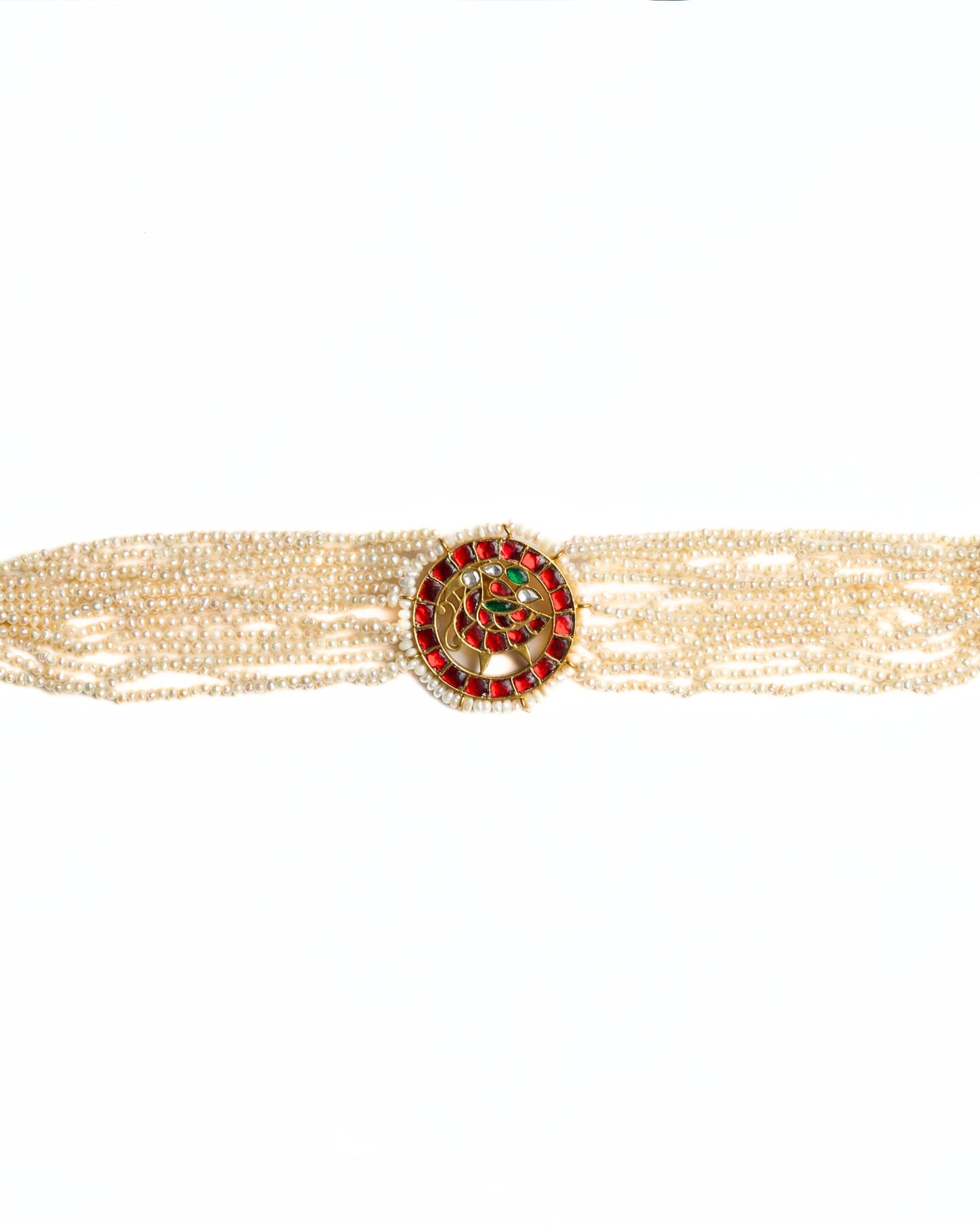 Close-up of a layered pearl choker in 925 silver with gold polish featuring a circular red stone peacock medallion at the centre.