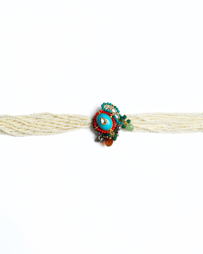 Multi-strand pearl choker with turquoise circular centre, teardrop kundan stone, red bead halo and green stone accents in 925 silver with gold polish.