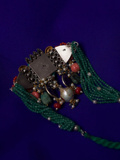 Close-up of Jewel of the Court Choker in 92.5 silver with parrot motifs, carved red center stone, kundan accents, coral and pearl drops