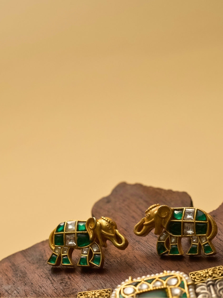 Pure 925 silver elephant-shaped stud earrings with gold polish, moissanite-like stones, and green accents by Naksa.