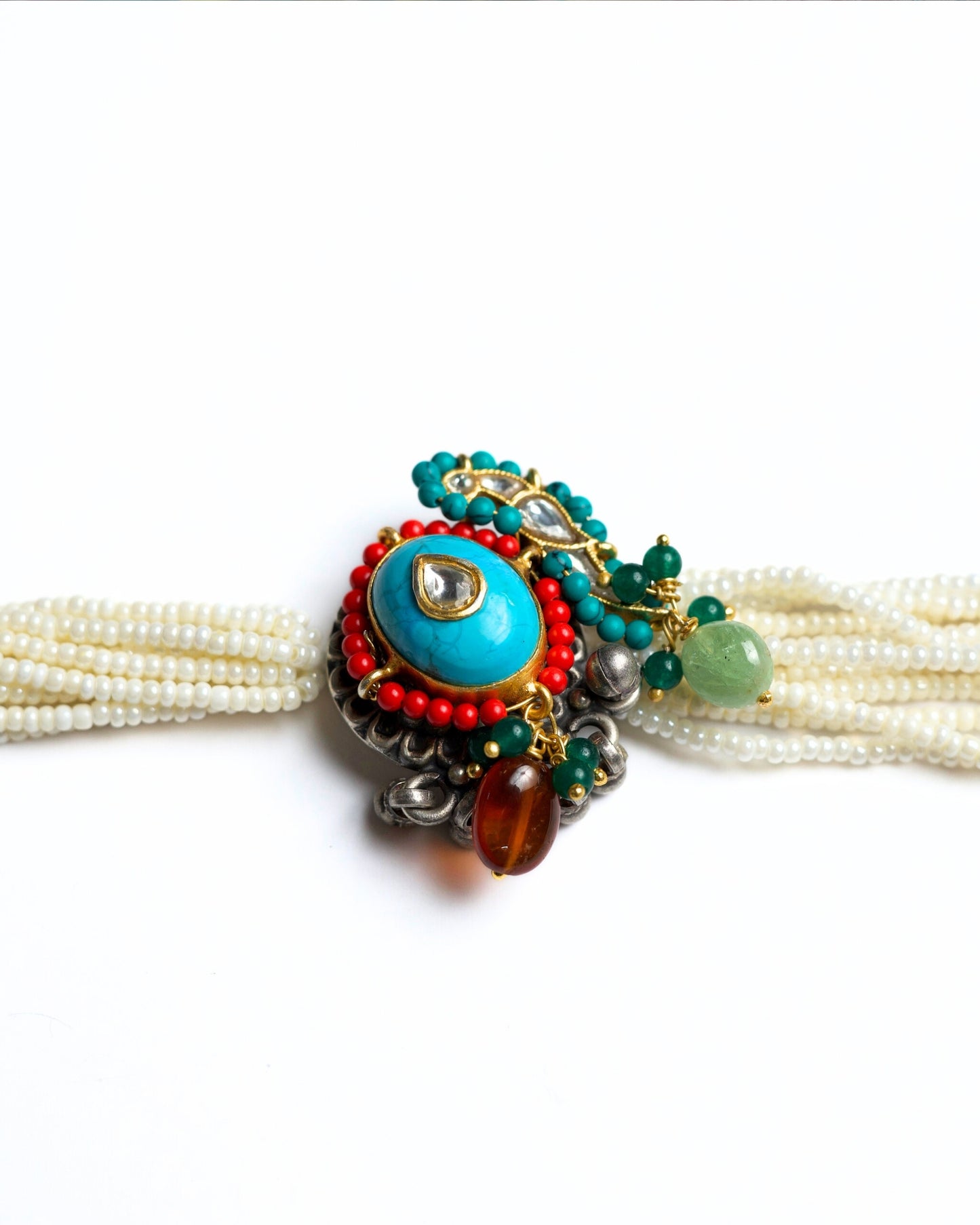 Multi-strand pearl choker with turquoise circular centre, teardrop kundan stone, red bead halo and green stone accents in 925 silver with gold polish.