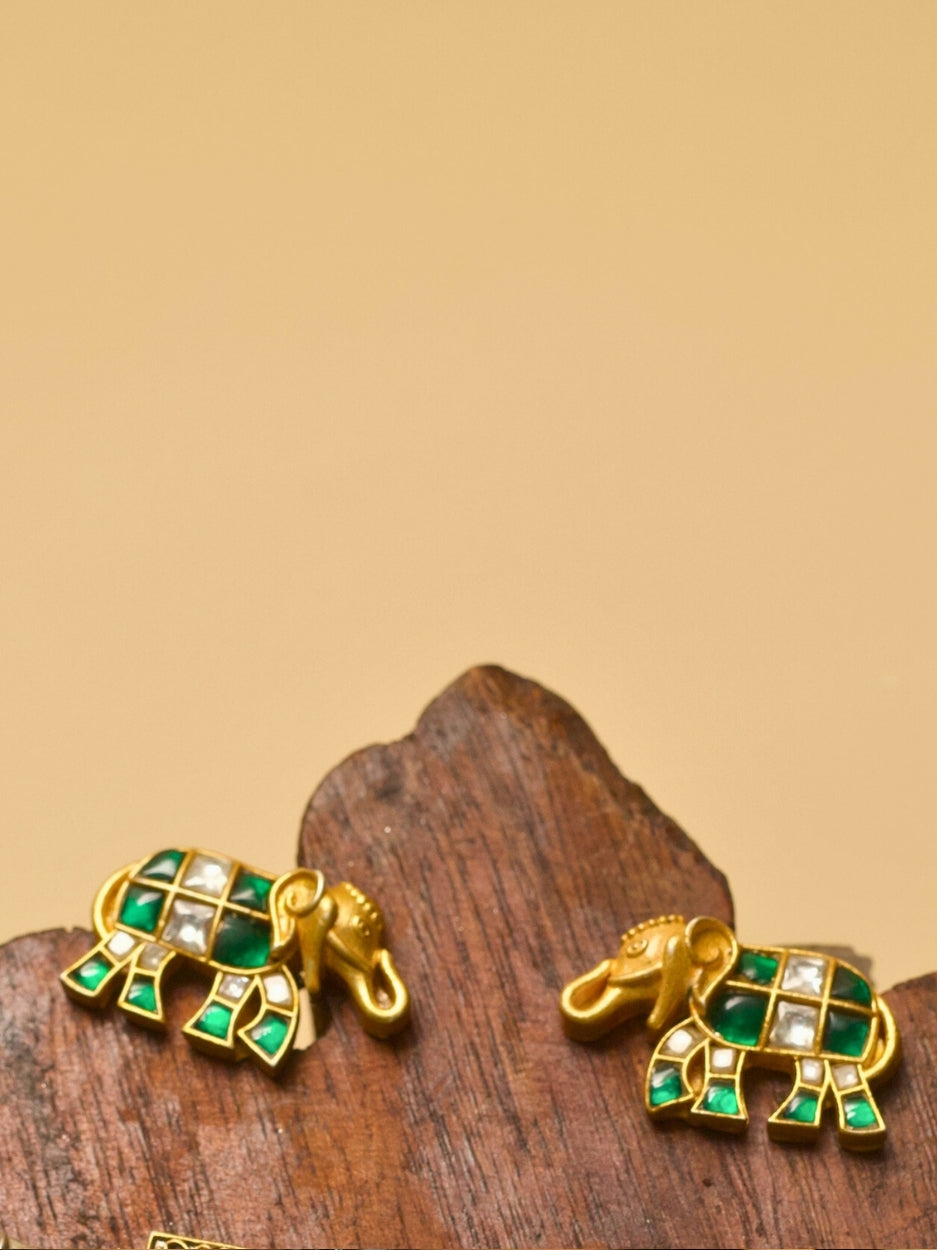 Pure 925 silver elephant-shaped stud earrings with gold polish, moissanite-like stones, and green accents by Naksa.